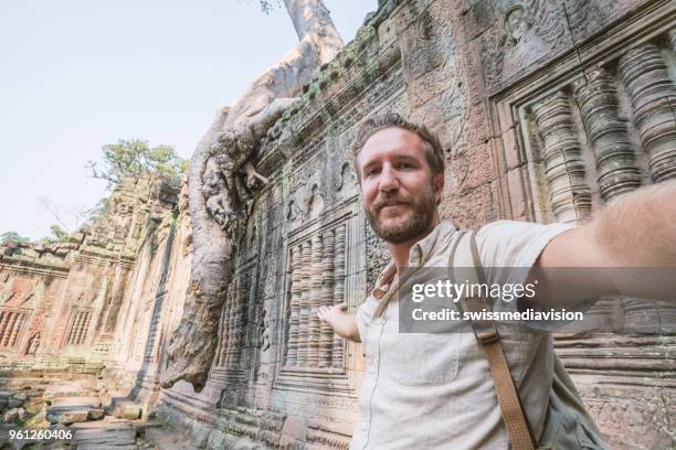 travel young man taking selfie portrait at ancient temple; young people traveling asia wonderlust concept - banteay kdei stock pictures, royalty-free photos & images