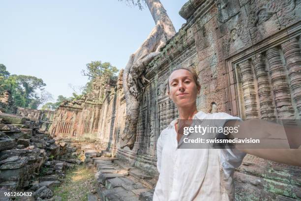 travel female taking selfie portrait at ancient temple; young people traveling asia wonderlust concept - banteay kdei stock pictures, royalty-free photos & images