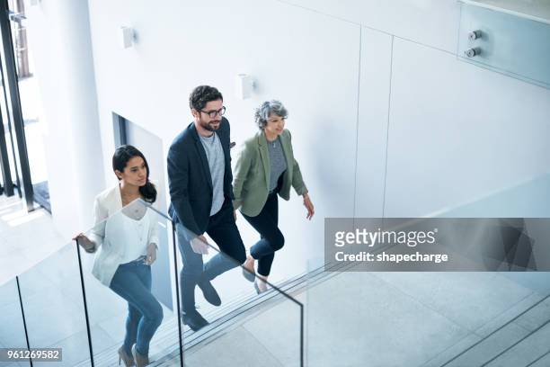 the go getters have entered the building - staircase stock pictures, royalty-free photos & images