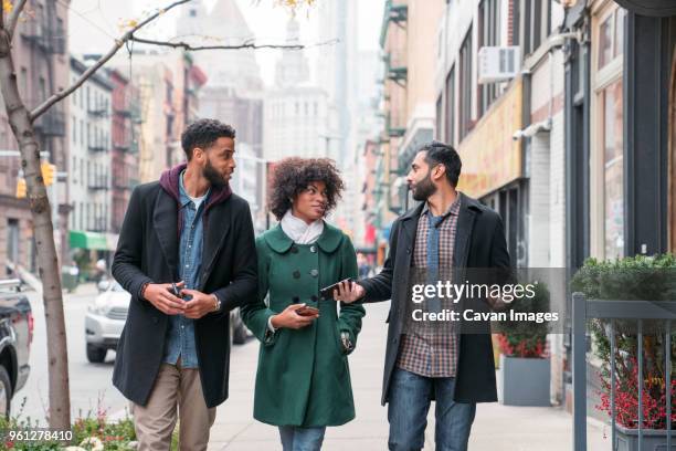 business people talking while walking on footpath in city - museum of the city of new york winter ball stockfoto's en -beelden