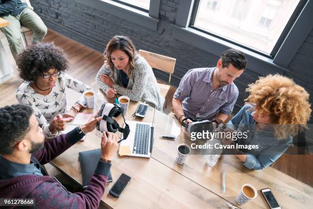 high angle view of business people examining virtual reality simulator in office - black man high 5 stockfoto's en -beelden
