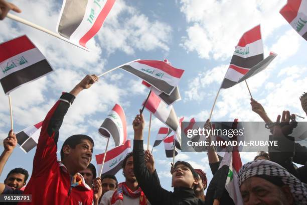 Iraqi Shiite Muslim youth wave their national flag during a protest against the earlier visit of US Vice President Joe Biden and against the Baath...