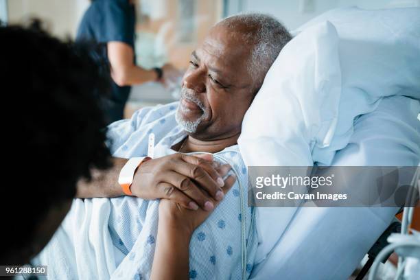 father consoling daughter while female doctor working in background - salman bildbanksfoton och bilder