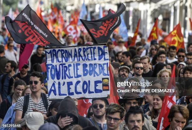 Protester holds a placard reading "Macron stop wreaking havoc in schools" during a demonstration on May 22 in Lyon, central-eastern France, as part...