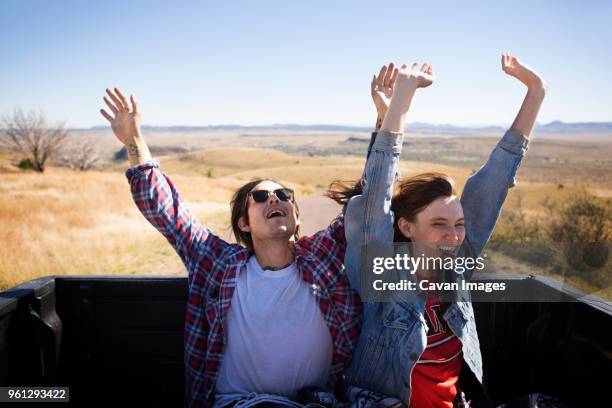 happy couple with arms raised traveling in pick-up truck - marfa bildbanksfoton och bilder