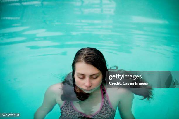 woman standing with eyes closed in swimming pool - swimwear singlet stock pictures, royalty-free photos & images