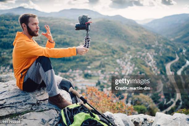 influencer tourist hiking and vlogging on the mountain top - the weekend in news around the world stock pictures, royalty-free photos & images