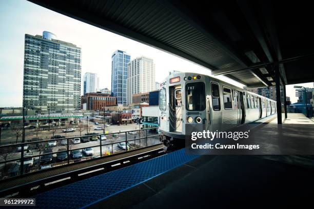 train at station against cityscape - chicago neighborhood stock-fotos und bilder