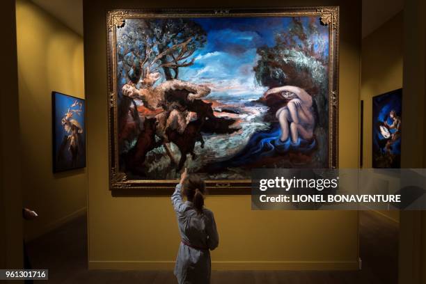 Girl looks at paintings by French artist Gerard Garouste displayed during the "Diane and Acteon" exhibition at the Museum of Hunting and Nature in...