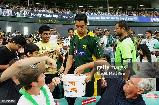 Umar Gul of Pakistan collects money from cricket fans for the victims of the recent Haiti earthquake during the second One Day International match...