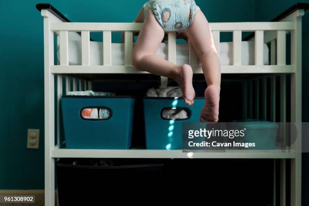 low section of boy climbing bunkbed at home - diaper boy fotografías e imágenes de stock