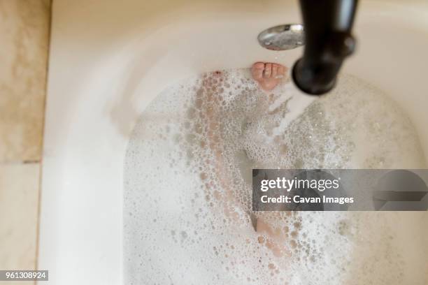 low section of boy in bath tub - running water bath stock pictures, royalty-free photos & images