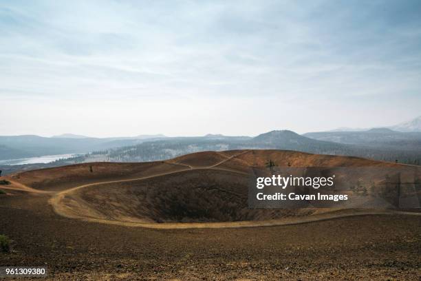 scenic view of volcanic landscape against cloudy sky during sunny day - cinder cone volcano stock pictures, royalty-free photos & images