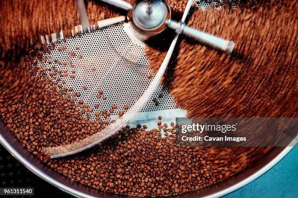 overhead view of coffee beans in roaster - food and drink industry stock pictures, royalty-free photos & images