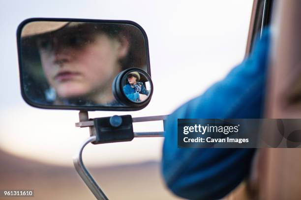 reflection of teenage cowboy on side-view mirror of vehicle - truck side view stock pictures, royalty-free photos & images