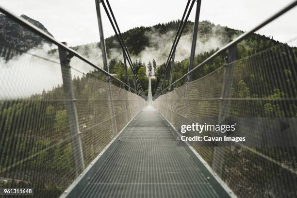 diminishing perspective of highline179 leading towards mountain against clear sky - hängebrücke stock-fotos und bilder