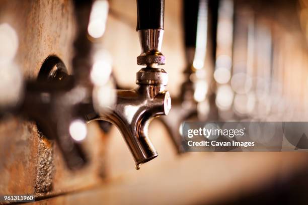 close-up of metallic beer taps at bar - beer pump stock pictures, royalty-free photos & images