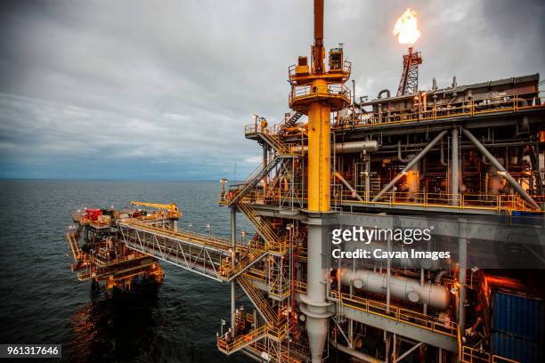 oil rig in sea emitting fire - oil rig fire stock pictures, royalty-free photos & images