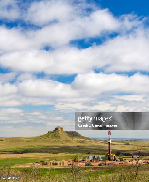 oil production platform on field against cloudy sky - plataforma para la exploración de petróleo fotografías e imágenes de stock