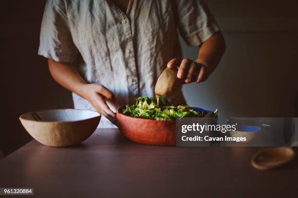 midsection of woman adding oil to avocado and spinach salad at home - avocado oil stock pictures, royalty-free photos & images