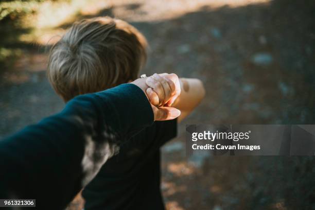 cropped images of mother holding hands of son - child and unusual angle stockfoto's en -beelden