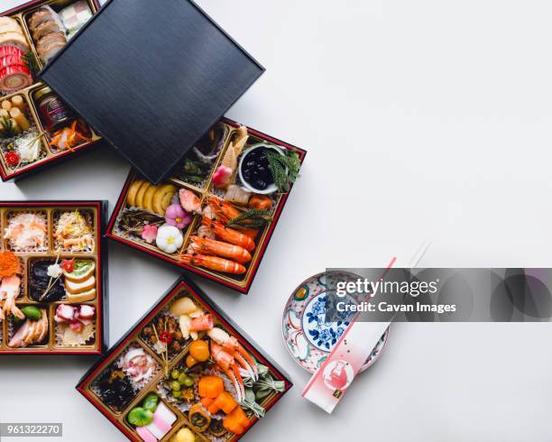 overhead shot of osechi-ryori on white background - bento box stock-fotos und bilder