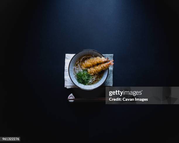 overhead shot of soba noodles served with crunchy shrimp tempura in bowl on table - 天ぷら ストックフォトと画像