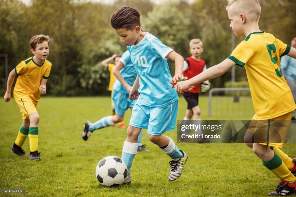 サッカーの試合中にボールを奪い合う 2 人の少年サッカー チーム