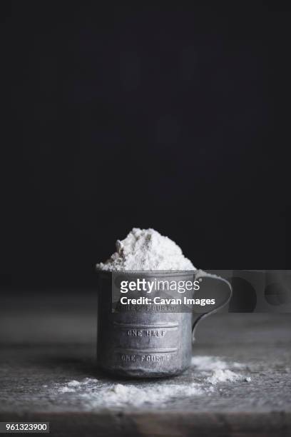 close-up of flour in measuring cup on table - mehl stock-fotos und bilder