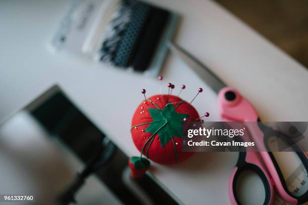 high angle view of pin cushion and scissor on table - pin cushion stockfoto's en -beelden