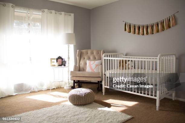 crib by armchair at home - baby crib stock pictures, royalty-free photos & images