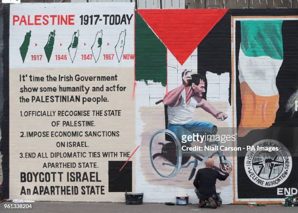 Belfast artist Marty Lyons paints a mural on the Falls Road of Palestinian Fadi Abu Salah, who lost his legs in 2008 in an airstrike and was killed...