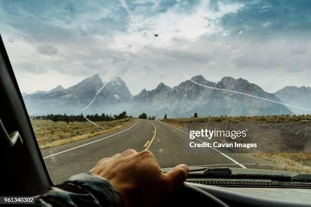 cropped hand of man driving truck - broken windshield stock-fotos und bilder