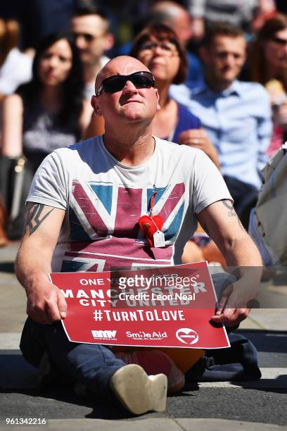 Man holds a #TurnToLove poster outside The Manchester Arena National Service of Commemoration at Manchester Cathedral on May 22, 2018 in Manchester,...