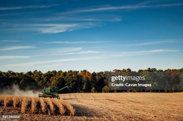 combine harvester on field against cloudy sky - michigan farm stock pictures, royalty-free photos & images