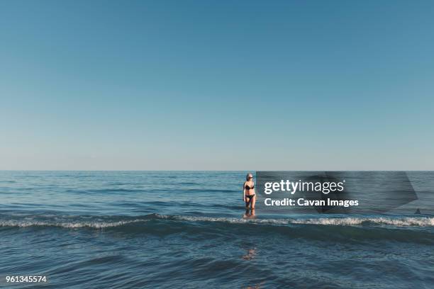 woman in sea against clear sky - bibione stock pictures, royalty-free photos & images