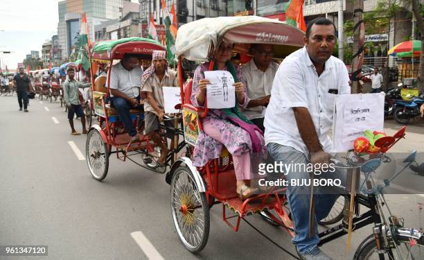 Activists of Assam Pradesh Congress Committee pull rickshaws and hand carts during a protest rally against the rise of fuel price in Guwahati on May...