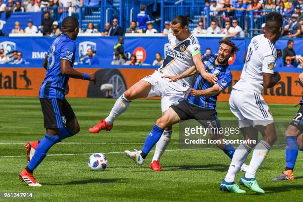 Los Angeles Galaxy forward Zlatan Ibrahimovic battles with Montreal Impact midfielder Marco Donadel to maintain control of the ball during the LA...