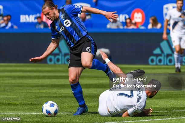 Montreal Impact midfielder Samuel Piette tries to avoid contact with Los Angeles Galaxy midfielder Romain Alessandrini while maintaining control of...