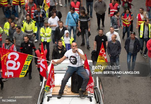 Protester standing on a car, waves a flag of CGT national trade union, during a demonstration on May 22, 2018 in Marseille, southeastern France, as...