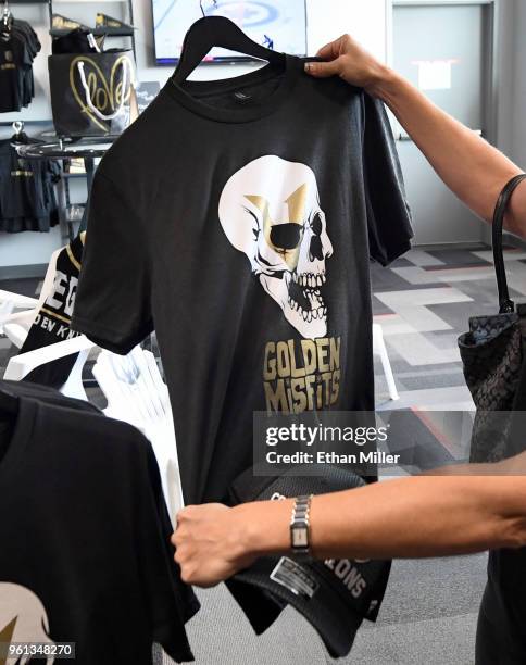 Vegas Golden Knights fan looks at a "Golden Misfits" T-shirt while shopping at the Arsenal retail store at City National Arena the day after the team...