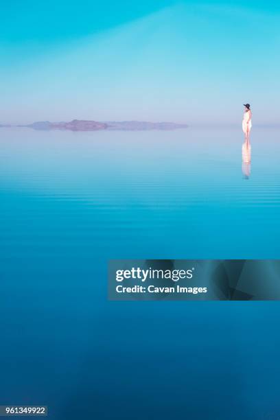 distant view of woman standing in lake at bonneville salt flats - bonneville salt flats 個照片及圖片檔