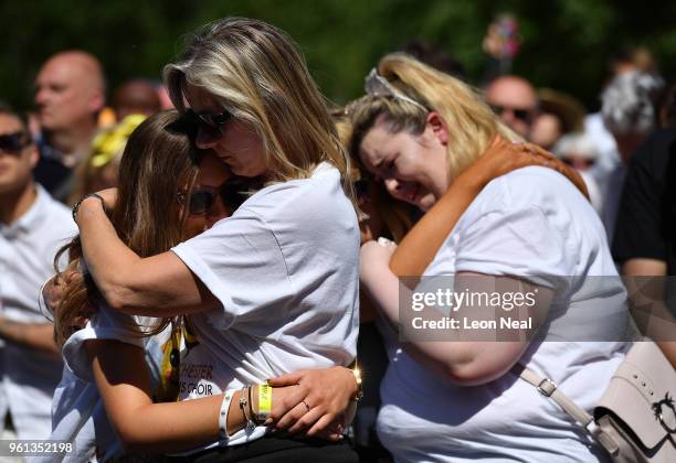 People hug as they observe one minute silence as they watch the outside broadcast of The Manchester Arena National Service of Commemoration at...