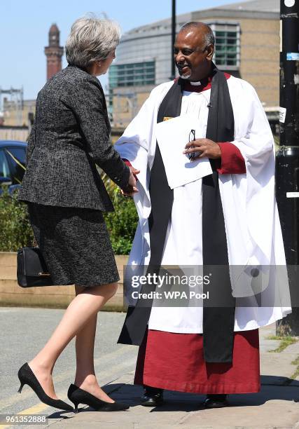British Prime Minister Theresa May is greeted by the Dean of Manchester, The Very Revd Rogers Govender, as she attends The Manchester Arena National...
