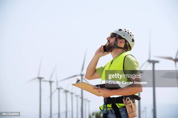 engineer using smart phone at wind farm - mature man using phone tablet stock pictures, royalty-free photos & images