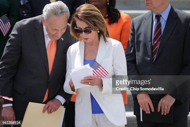 Senate Minority Leader Chuck Schumer and House Minority Leader Nancy Pelosi look over notes during an event to introduce a new campaign to retake...