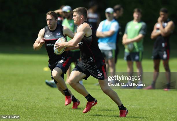 Owen Farrell runs with the ball with team mate Chris Wyles in support during the Saracens training session held at Old Albanians on May 22, 2018 in...