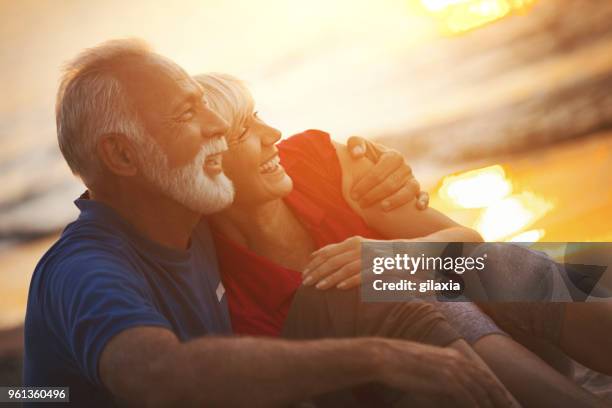 senior couple on a romantic evening. - older couple hugging on beach stock pictures, royalty-free photos & images