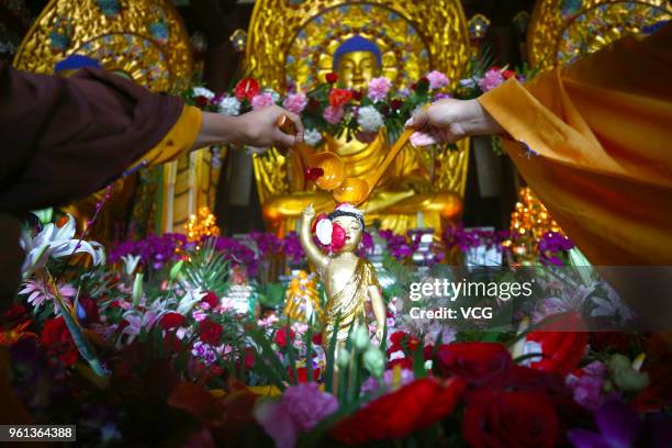 Monks bath the statue of buddha to mark the 2,562nd birthday of Buddha on the eighth day of the fourth month in Chinese lunar calendar at Nanshan...