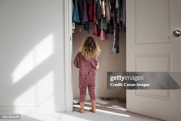 rear view of girl standing at closet - childrens closet stock pictures, royalty-free photos & images